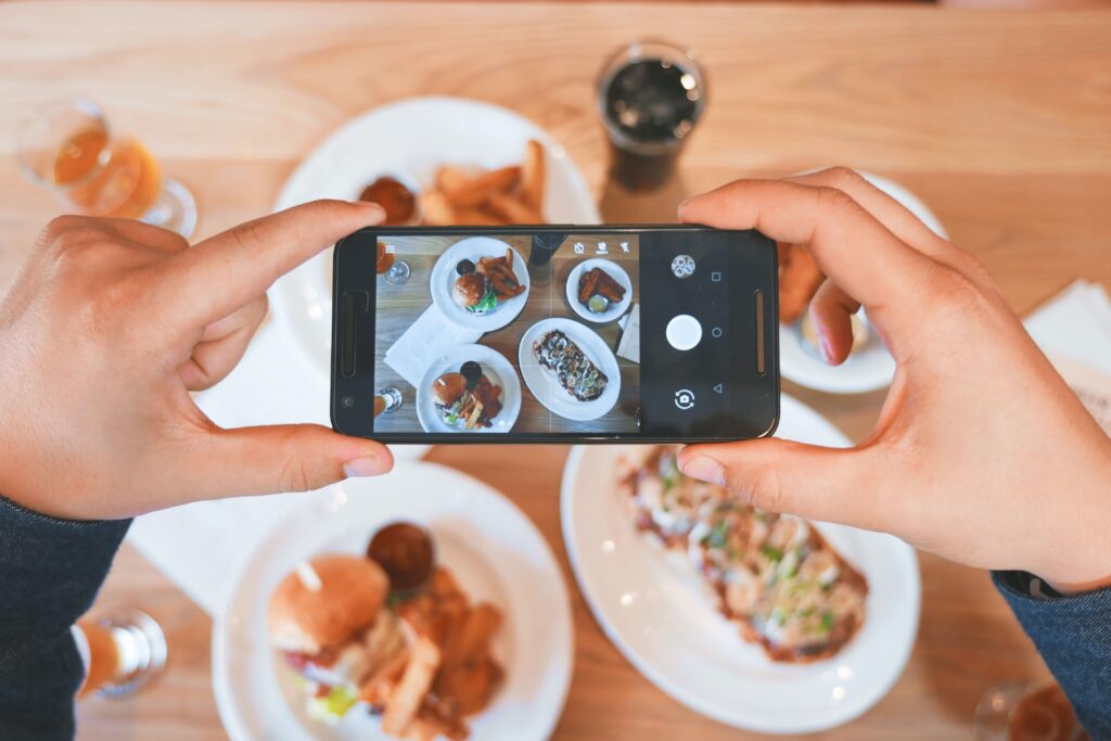 A person taking a photo of their restaurant food with a phone camera
