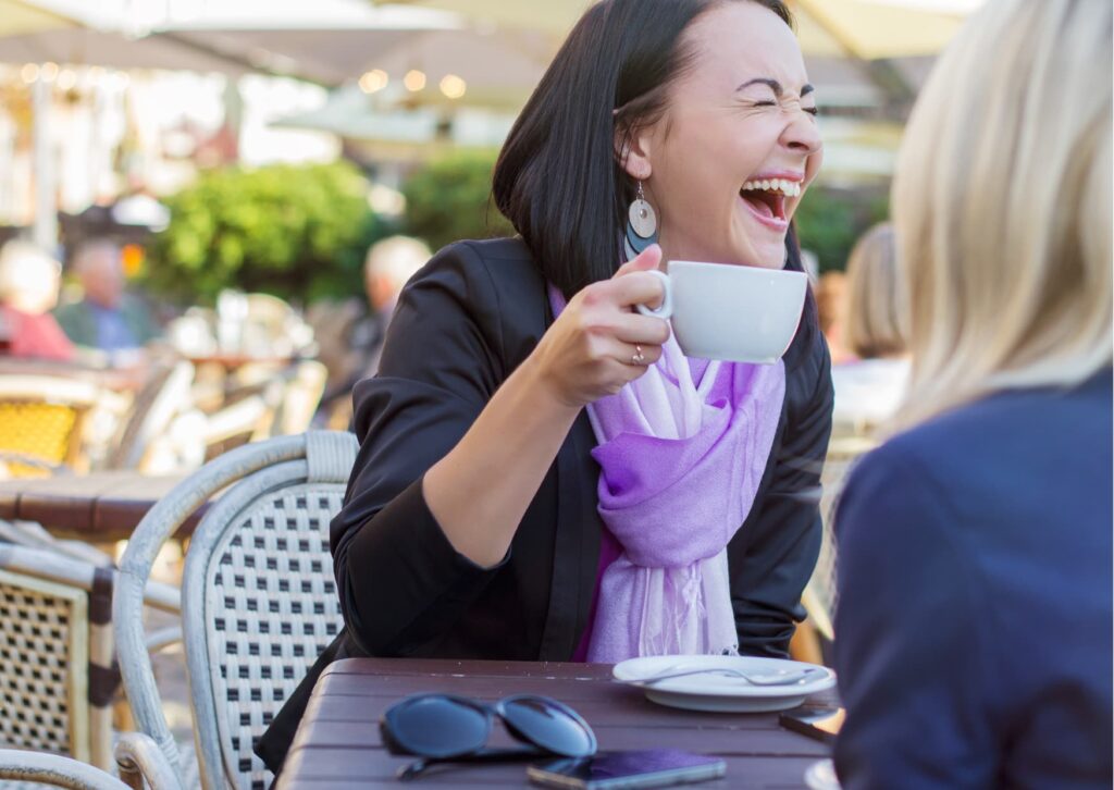 Woman drinking coffee and laughing