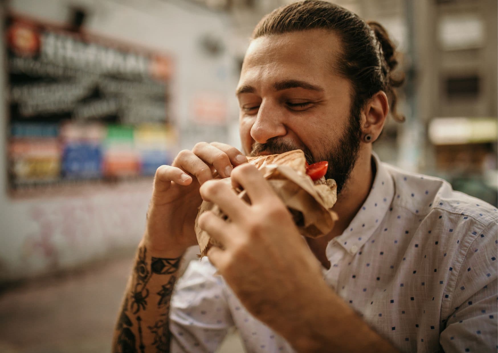 Man eating Serbian street food pljeskavica