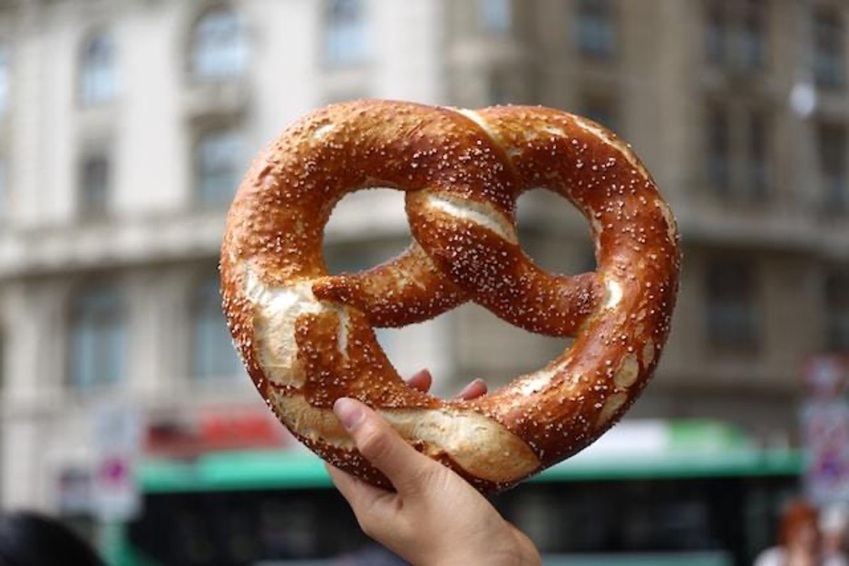 A hand holding a pretzel.