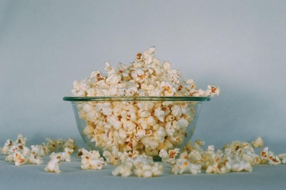 a glass bowl full of popcorn.