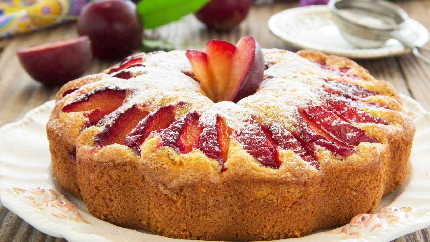 Plum cake with plums in the background