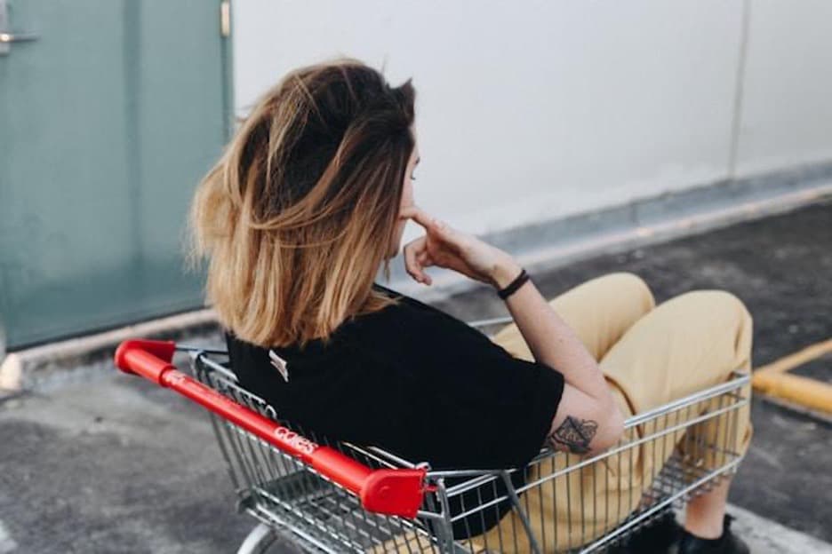 A woman sitting in a shopping cart.
