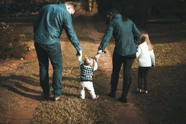 Parents and two children walking on a country path.