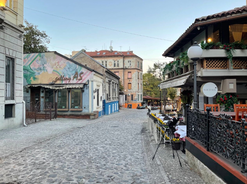 A cobblestone street in Belgrade with taverns lined up.