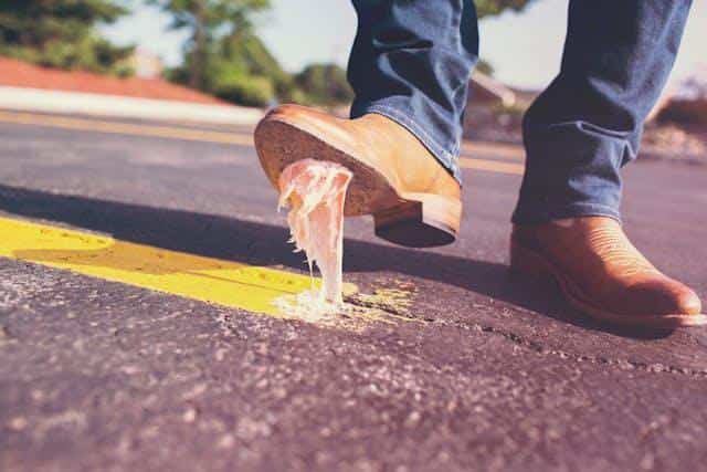 A man stepping on chewing gum, illustrating baksuz — one of the Turkish words in Serbian.