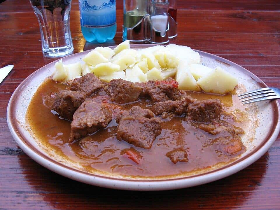 Beef stew and potatoes in a bowl.