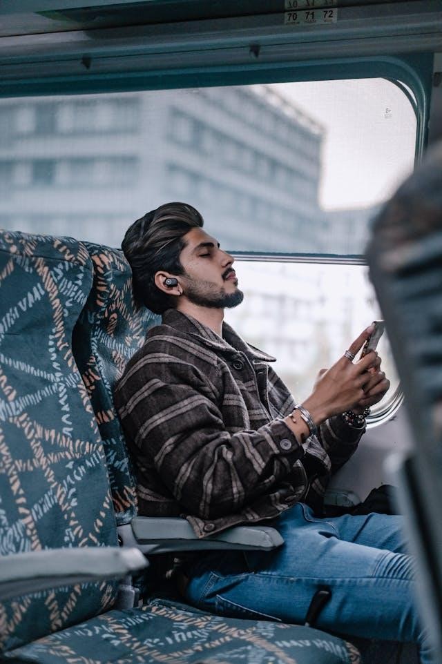 A man sitting inside a bus listening to music.