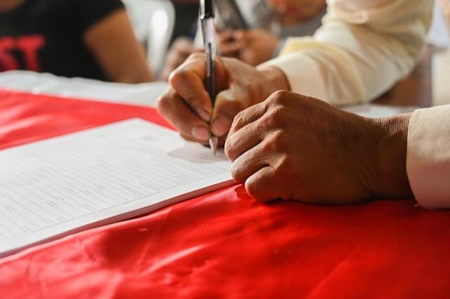 A man signing a form.