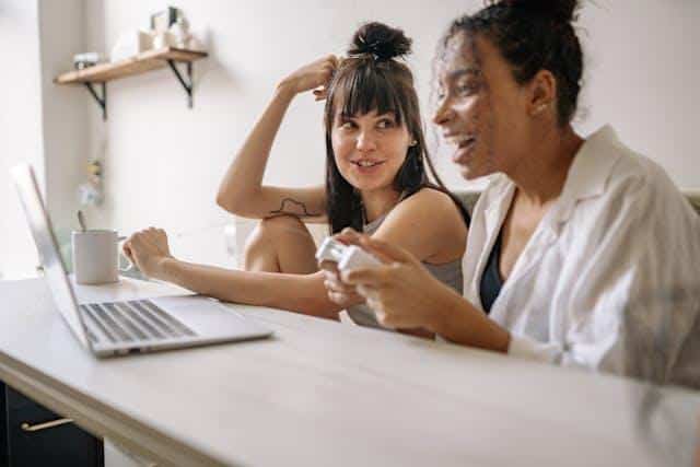 Two women in front of a laptop studying Serbian phrases for expats.
