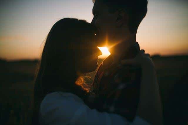 A man and a woman hugging against a sunset backdrop, illustrating Serbian for dating.