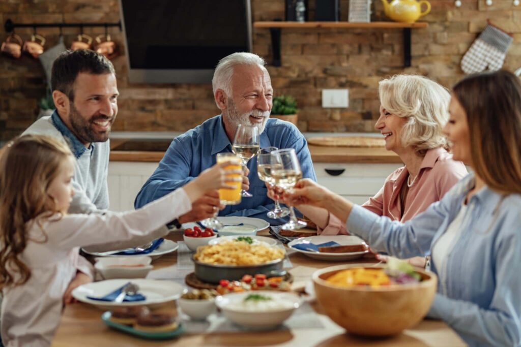 A family gathered around a dining table, sharing a meal and toasting