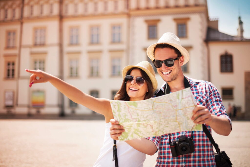 A couple of smiling tourists sightseeing with a map